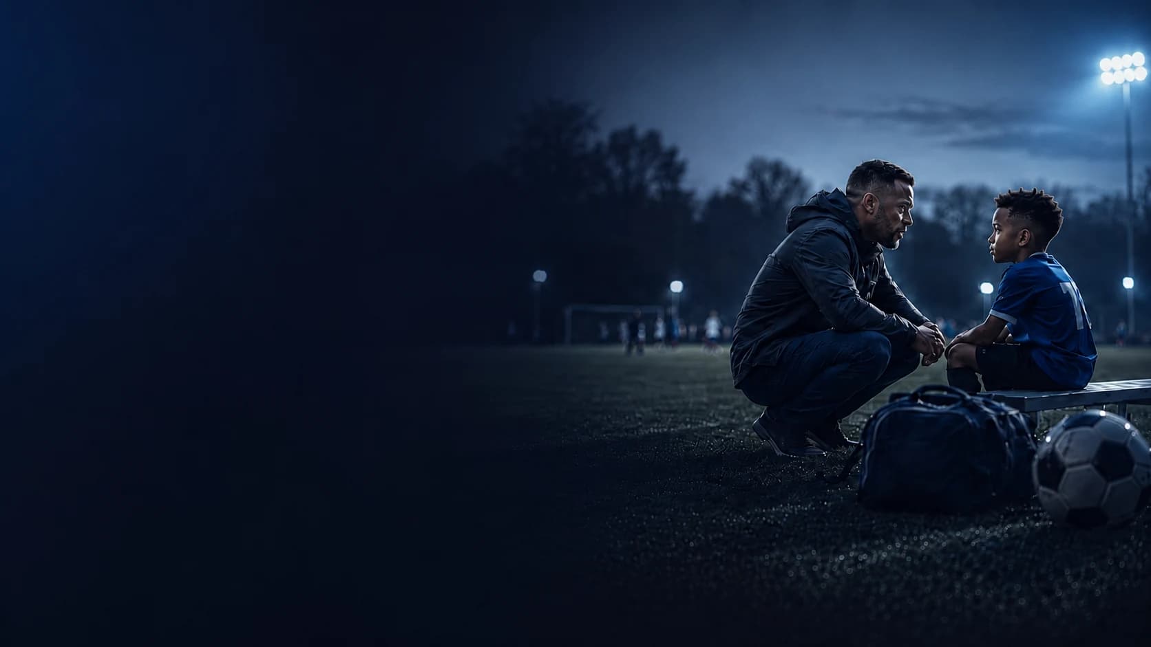 Parent and player talking beside a soccer field